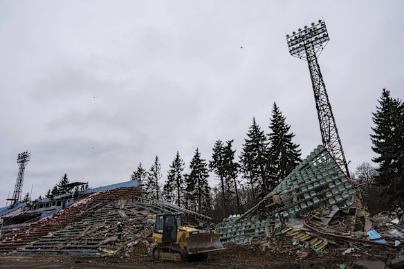 A bulldozer clears the remains of a stadium destroyed by Russian shelling in Chernihiv.