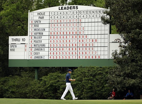 Jordan Spieth walks under a leaderboard on the 11th fairway.