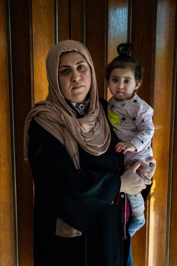 Qammar Haitham, 34, holds her daughter at home near the town of Balad, Iraq, on February 4. Haitham uses a breathing tube fitted to aid breathing difficulties.