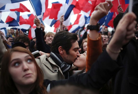 Supporters of French independent centrist presidential candidate, Emmanuel Macron kiss as they celebrate outside the Louvre museum in Paris.