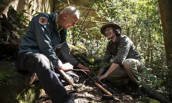 David Crust, NPWS Director Blue Mountains Branch, and Atticus Flemming, Deputy Secretary NPWS, plant a young Wollemi Pine in a wild translocation site in a canyon in the Wollemi Wilderness Area. 