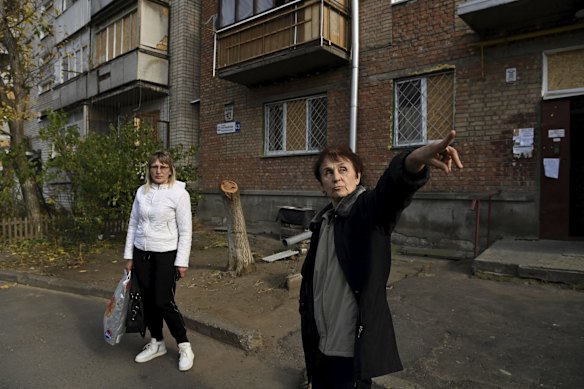 Valentyna Khazan, 55, and Olena Siyanko, 71, stand in front of their apartment building that remains intact after it was impacted by the S300 missile strike that killed Artem on October 13.
