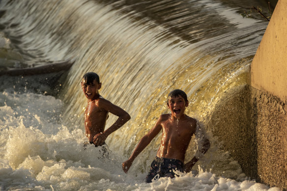 Two boys play in the Barwon-Darling River near Brewarrina Weir: there are thousands of obstructions built on Australian rivers, inhibiting fish movement.