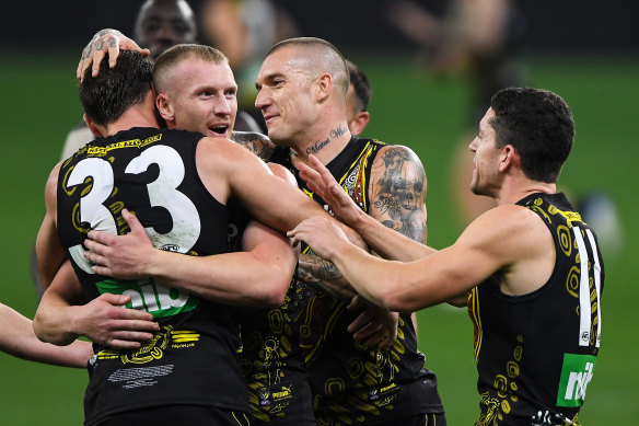 Kamdyn McIntosh, Josh Caddy and Dustin Martin celebrates a goal.