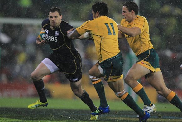 Scotlands Sean Lamont tries to evade two Wallaby defenders.