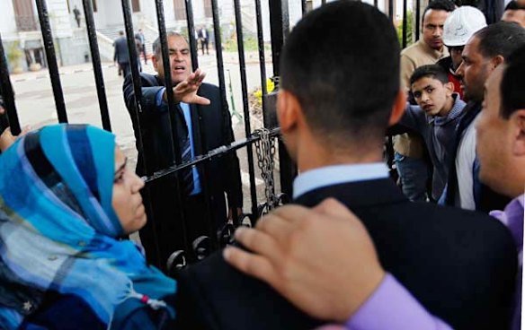 An Egyptian official tries to calm a group of anti-government protesters demonstrating outside the Ministry of Health building.