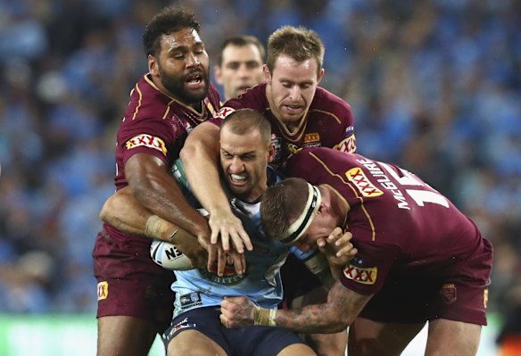 Blake Ferguson of the Blues is tackled by Sam Thaiday and Josh McGuire of the Maroons.