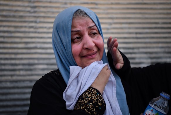 A woman weeps with relief as she waits to be taken to displaced peoples camps by truck at a screening point in West Mosul after being rescued by Iraqi forces from Islamic State held areas.