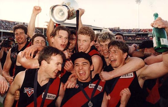 James Hird (fourth from left) and Mark Thompson, right celebrate winning the 1993 grand final with Essendon.