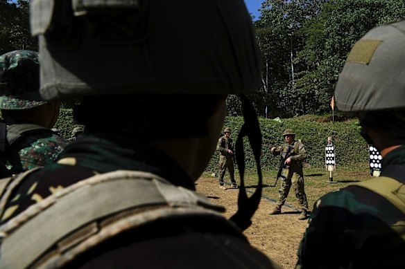 Corporal Robert Druery (2nd from right) and Private Daniel Martin (3rd from right) with the 8th/9th Royal Australian Regiment and Land Mobile Training Team during training at the firing range.