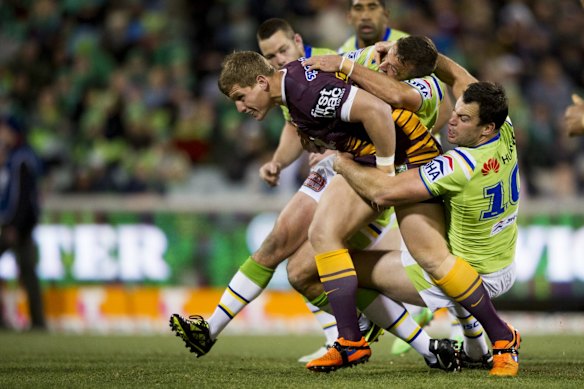 Jarrod Wallace of the Brisbane Broncos is taken down by Riaders David Shillington and Josh Hodgson.