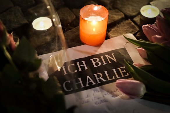 BERLIN, GERMANY - JANUARY 07:  A candle is lit near a paper with the written words "I am Charlie" in German at a vigil in front of the French Embassy following the terrorist attack in Paris on January 7, 2015 in Berlin, Germany. 