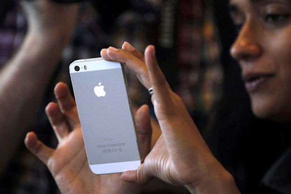 A woman tries the silver version of the new iPhone 5S.