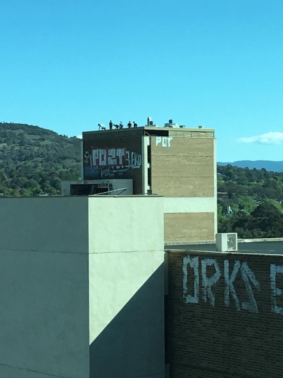 People on the roof of the abandoned Woden building on Monday afternoon.