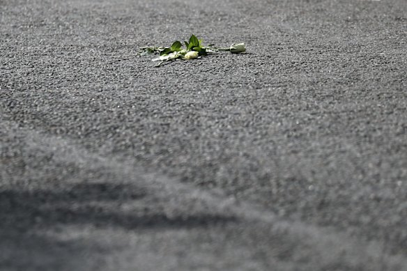 A flower lays on a road in Ballater, Scotland, after the hearse carrying the coffin of Queen Elizabeth II passed through as it makes its journey to Edinburgh from Balmoral in Scotland, Sunday, Sept. 11, 2022. The Queen's coffin will be transported Sunday on a journey from Balmoral to the Palace of Holyroodhouse in Edinburgh, where it will lie at rest before being moved to London later in the week. (AP Photo/Scott Heppell)