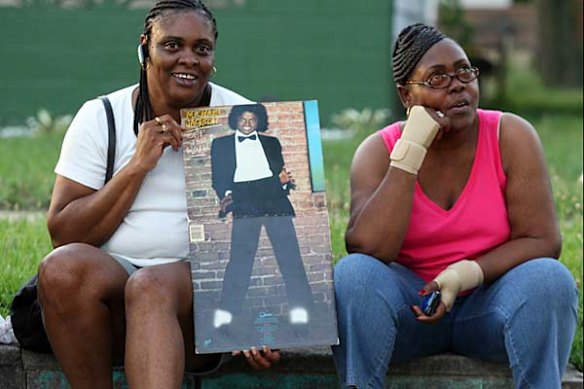 A woman holds an old record album of Pop Star Michael Jackson's outside his former childhood home on June 25, 2009 in Gary, Indiana.