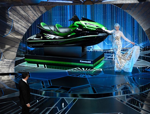 Helen Mirren displays a jet ski to be presented to the Oscar winner who makes the shortest acceptance speech, as host Jimmy Kimmel looks on.