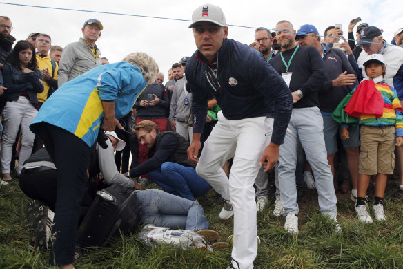 US golfer Brooks Koepka offers a golf glove to a spectator he injured when his ball strike hit her.