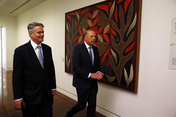 Senator Mathias Cormann and former home affairs minister Peter Dutton arrives for a party room meeting at Parliament House in Canberra.