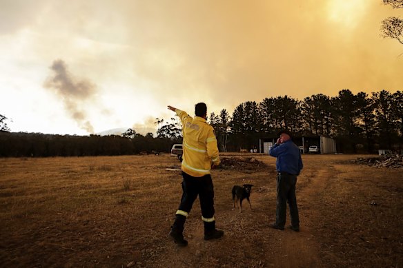 Fire crews work to defend Bombay resident Les Hart's property as the North Black Range bushfire approaches, seen near Bombay, NSW.