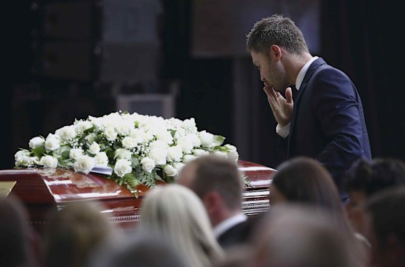 Michael Clarke pauses at his friend Phillip Hughes' casket as he makes his way to the lectern to deliver his tribute.