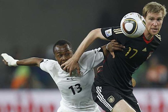 Germany's Per Mertesacker fights for the ball with Ghana's Dede Ayew