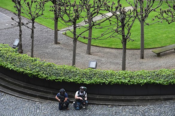 Armed police take cover outside the the Houses of Parliament, London.