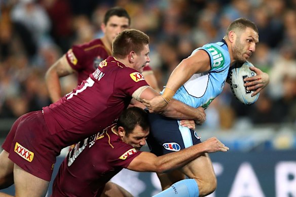 Robbie Farah of the Blues is tackled.