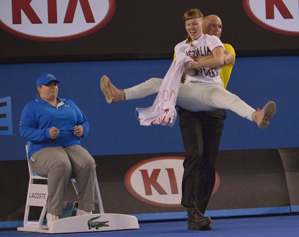 A protester is carried from the court at Rod Laver Arena during the Men's Final.