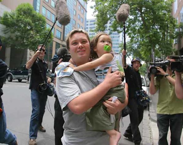 Carl Williams clutches his daughter Dhakoda as he leaves the Melbourne Magistrates Court on bail in 2003.
