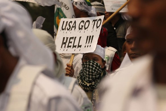 A man holds a sign "USA GO TO HELL" as he joins hundreds of protestors gathered for anti US protests at the Bunderan Hotel Indonesia traffic circle in Central Jakarta, Indonesia.