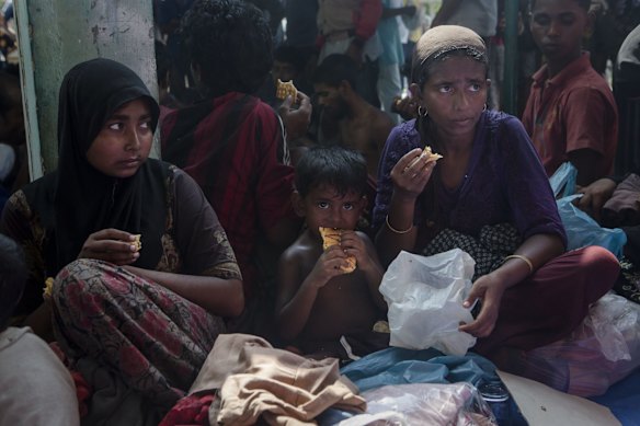 KUTA BINJE, INDONESIA - MAY 20:  Rohingya women and children eat after arriving at the port in Julok village on May 20, 2015 in Kuta Binje, Aceh Province, Indonesia.  Hundreds of Myanmar's Rohingya refugees have arrived in Indonesia, many requiring medical attention. Thousands more are believed to still be stranded at sea reportedly with no country in the region willing to take them in. Myanmar's Rohingya Muslim community have long been persecuted and marginalized by Myanmar's mostly Buddhist population.  