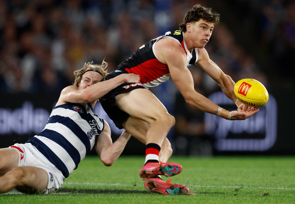 Tough battle: St Kilda’s Darcy Wilson offloads a handball while tackled by Zach Guthrie.