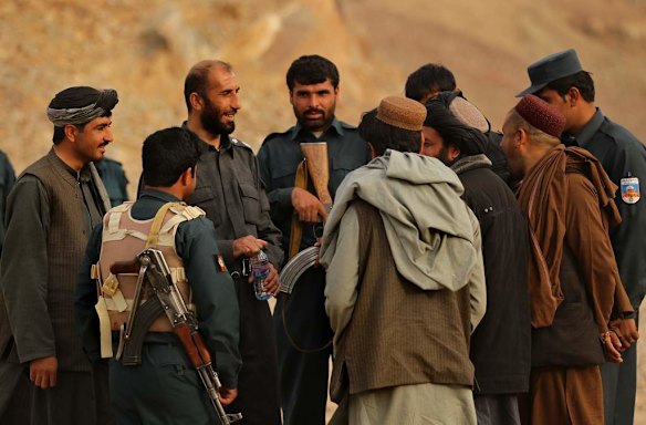 Uruzgan Police Chief, Matiullah Khan, 3rd from left, talks amongst his men on the Tarin Kowt to Kandahar highway, on the outskirts of Tarin Kowt town.