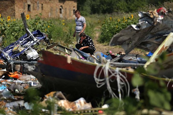 Donetsk People's Republic sniper Eugene Lukovkin (black pants) with his friend Valerie at one of the sites where Eugene witnessed the front section of Malaysian flight MH17 crashing and found the pilots bodies.