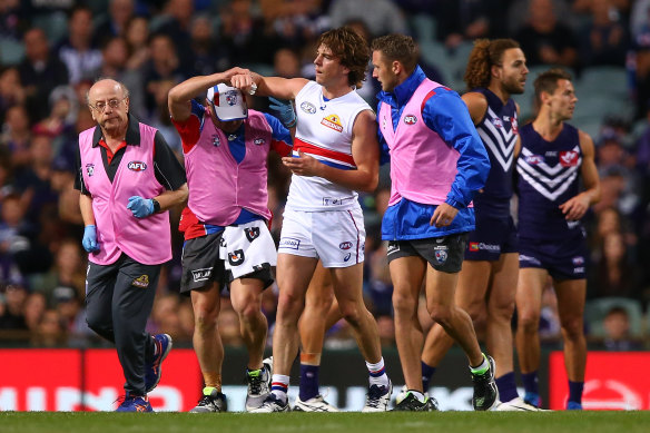 Concussion claim: Liam Picken needed help from club trainers and club doctor Jacob Landsberger after a heavy hit against Fremantle in 2017. His lawyer argued on Thursday his case against the AFL and the Western Bulldogs should not be part of a separate class action.