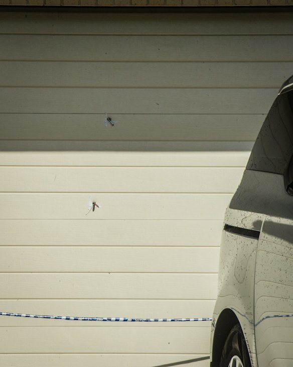 Police officers and forensic staff attend the scene of an overnight shooting and arson attack in Harrington circuit, Kambah. Numerous bullets have hit the home and three vehicles have been set alight. 