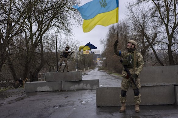 Ukrainian soldiers celebrate at a checkpoint in Bucha, on the outskirts of Kyiv.
