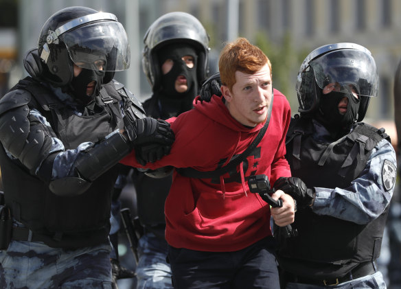 Police officers detain a protestor during an unsanctioned rally.