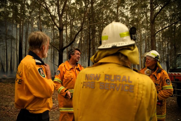 The NSW RFS Mogendoura unit discuss Saturday's plan while monitoring a fire. 