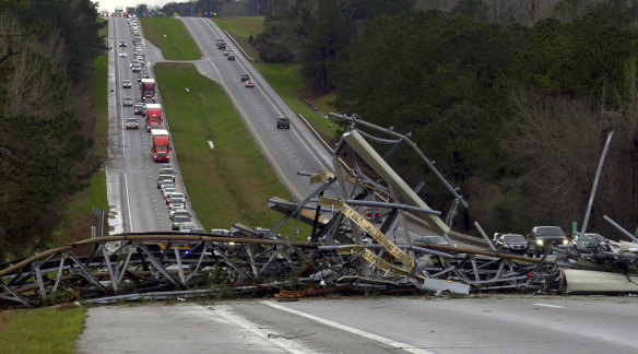 A fallen telephone tower lies across US Route 280 highway in Lee County, Alabama after a tornado struck on  Sunday.