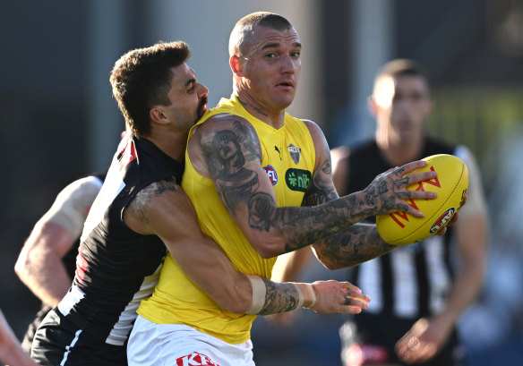 All wrapped up: Dustin Martin is tackled by Oleg Markov on a night the Magpies showed why they are premiership favourites.