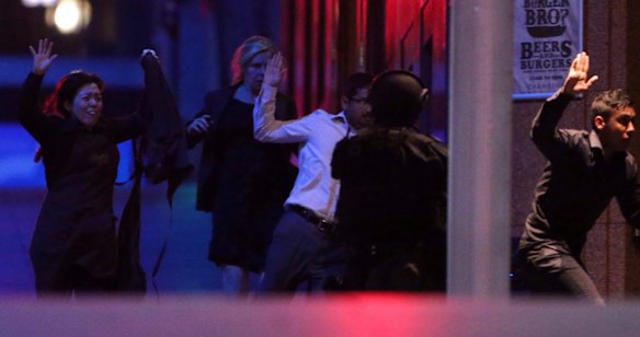 Hostages flee from the Lindt Chocolat Cafe in Martin Place during the shootout.