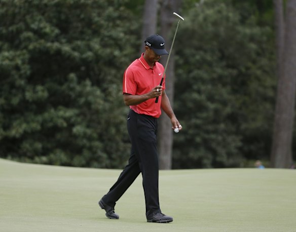 Tiger Woods walks off the 14th green after a bogie.