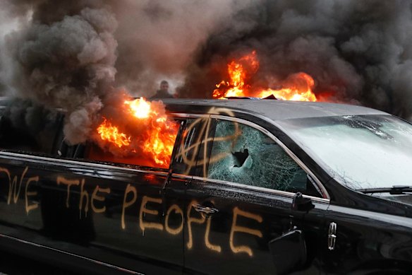 A parked limousine burns during a demonstration after the inauguration of President Donald Trump.