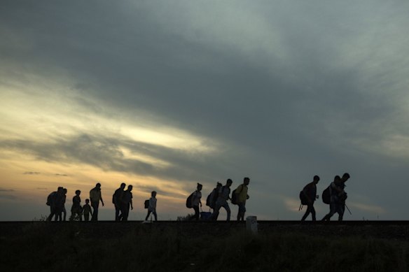 A group of refugees walk along the railway tracks near the town of Roszke, Hungary.