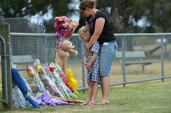 Friends arrive at the Tyabb oval to place flowers.