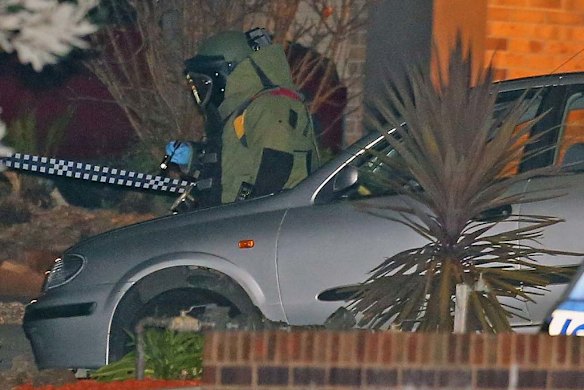 An bomb squad officer inspects the car.