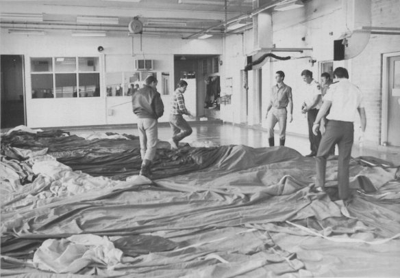 "Air safety officers inspect the balloon fabric from Sunday's fatal hot air balloon crash in the fire station at Alice Springs Airport." August 14, 1989.