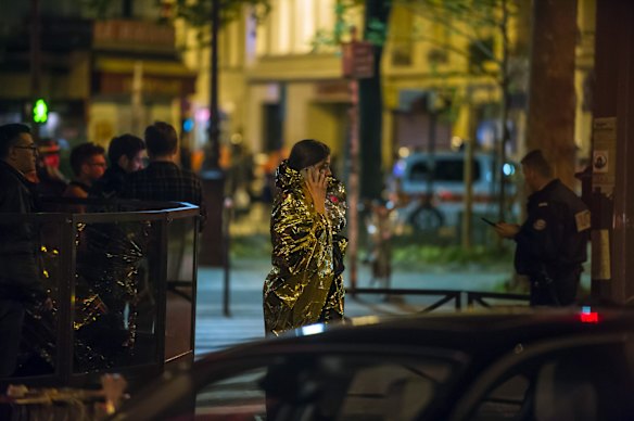 A victim makes a phone call as she walks away the Bataclan concert hall.